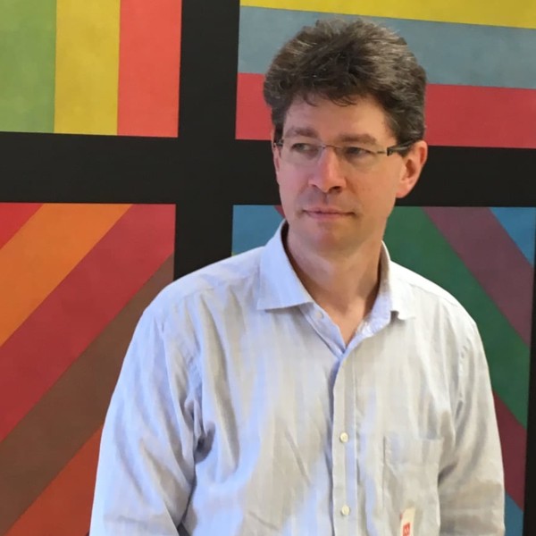 Geoff Hudson man in white shirt standing in front of Sol Lewit artwork