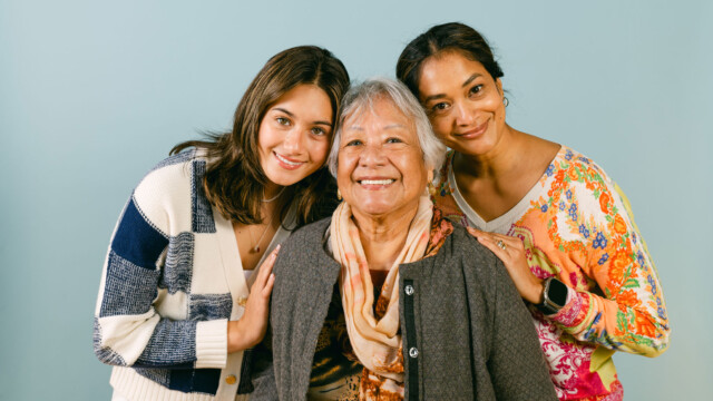 three women posing on a blue background