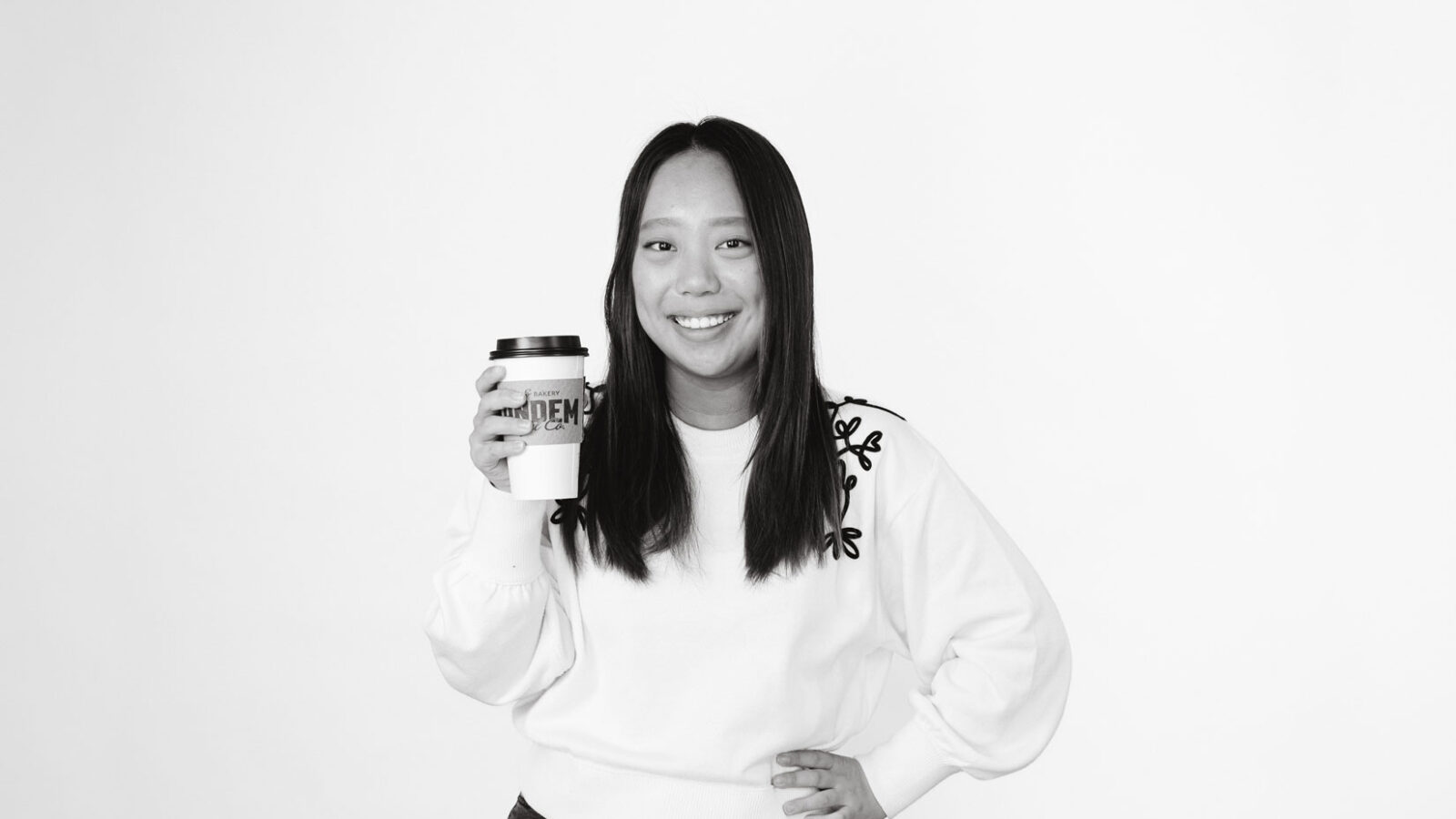 Student holding takeout coffee cup