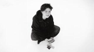 Student sitting on the ground with electronics