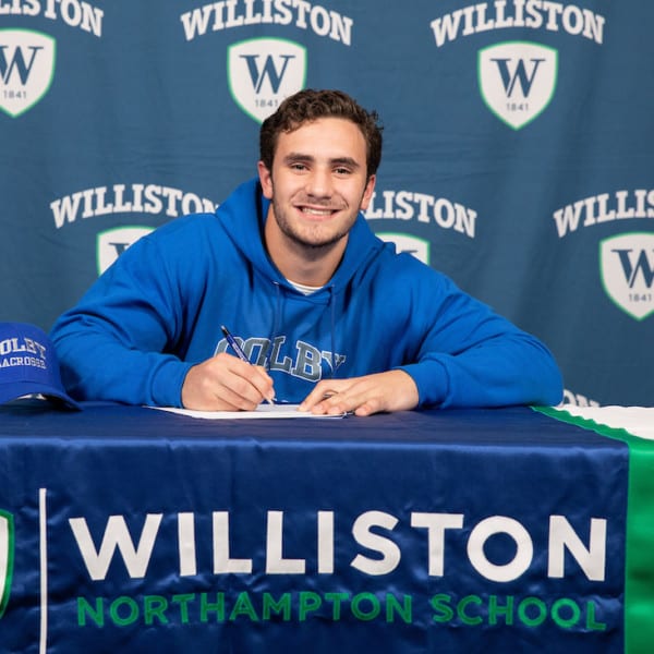 male student sitting at table with Williston northampton school insignia