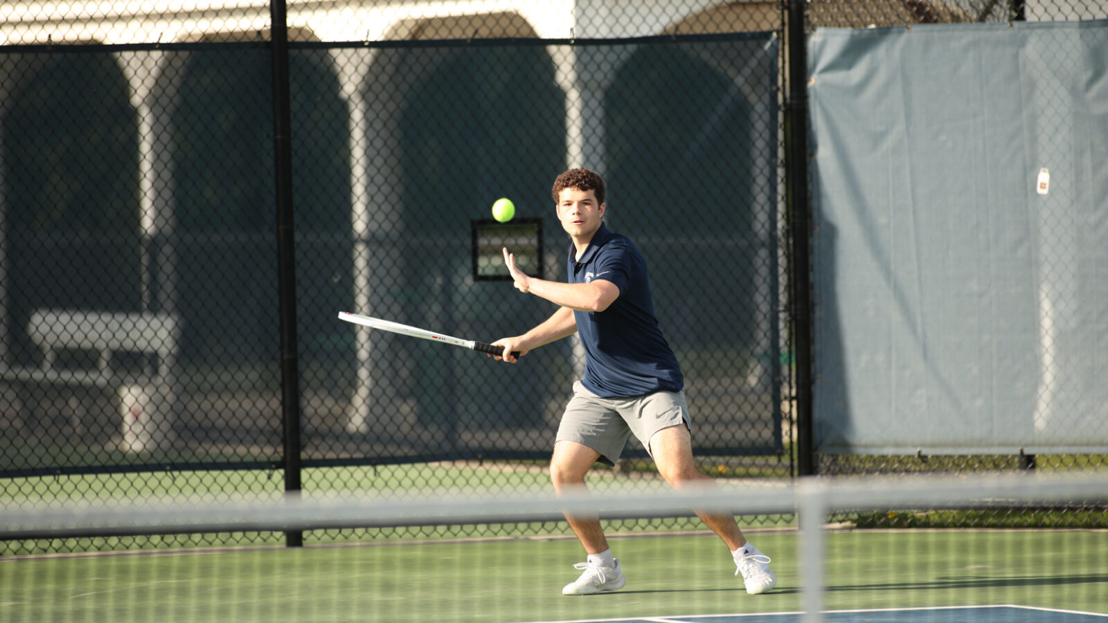 high school boy playing tennis