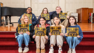 students on stairs posing with certificates