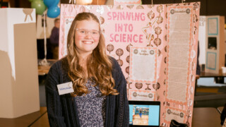 girl standing in front of science project