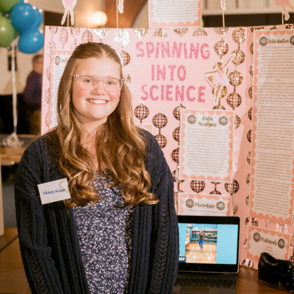 girl standing in front of science project