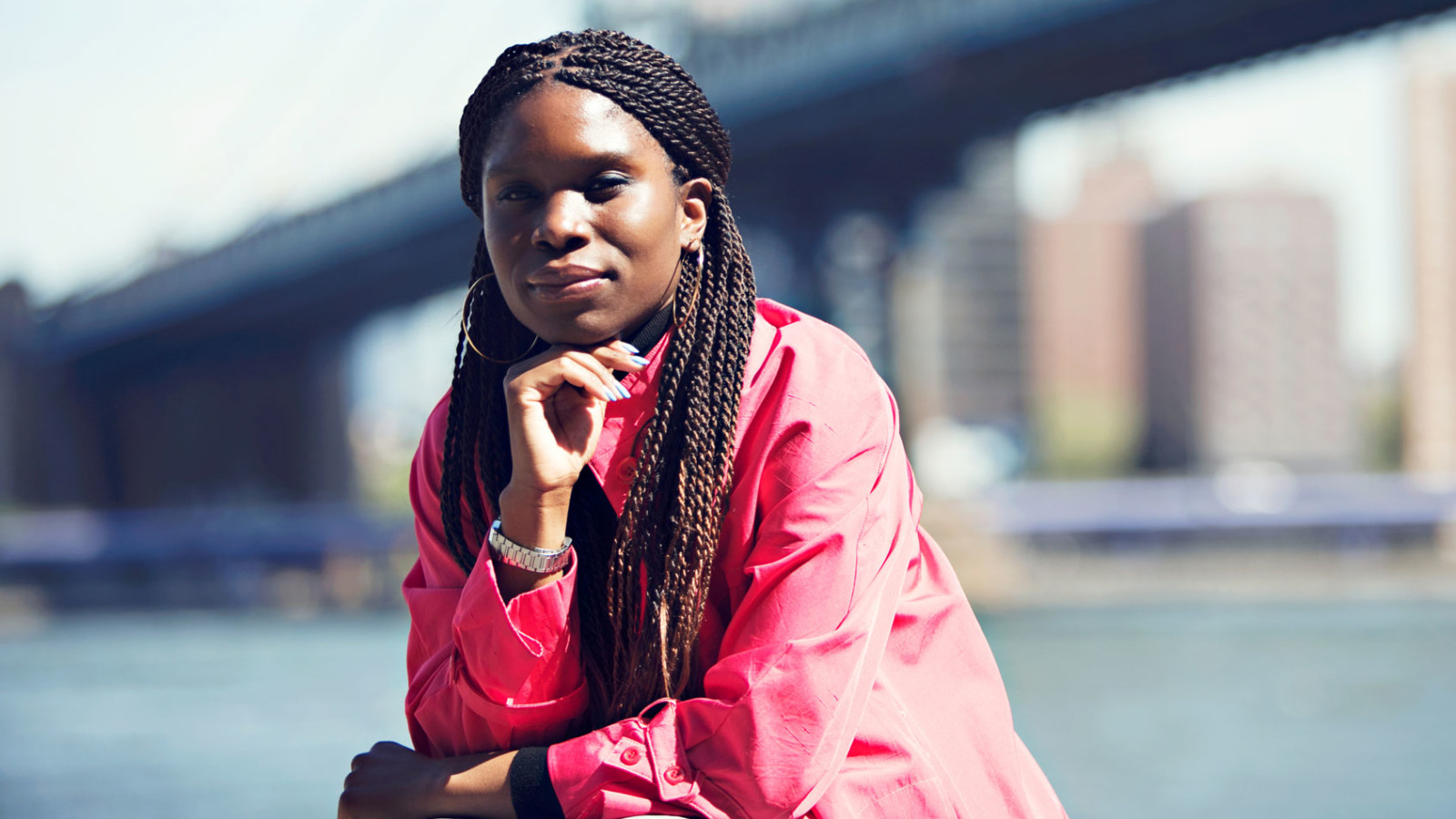 woman in front of a bridge over the East River in NYC