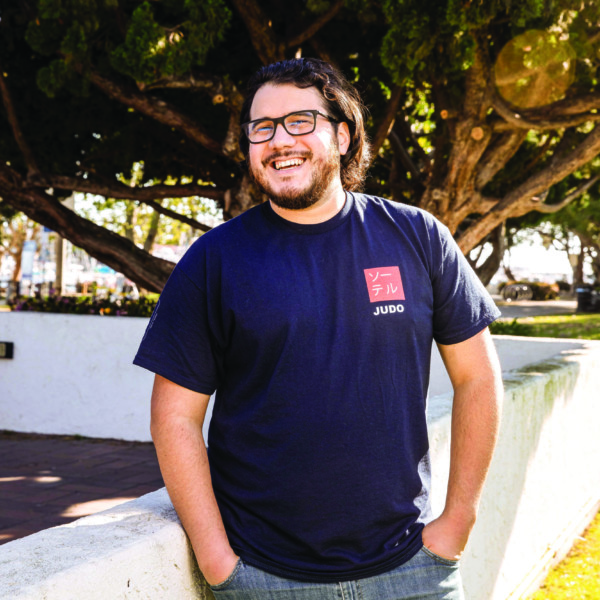 man outside near white wall